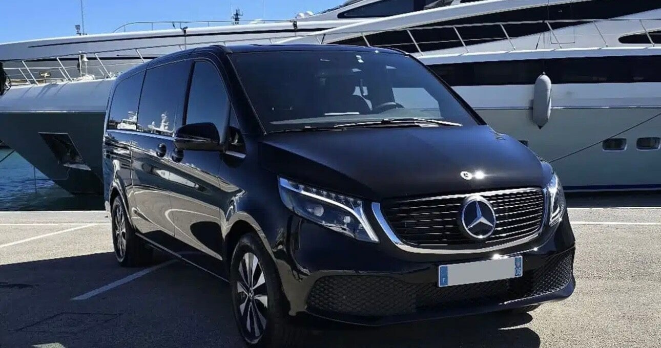 Van présenté par Transport Var, stationné devant des yachts